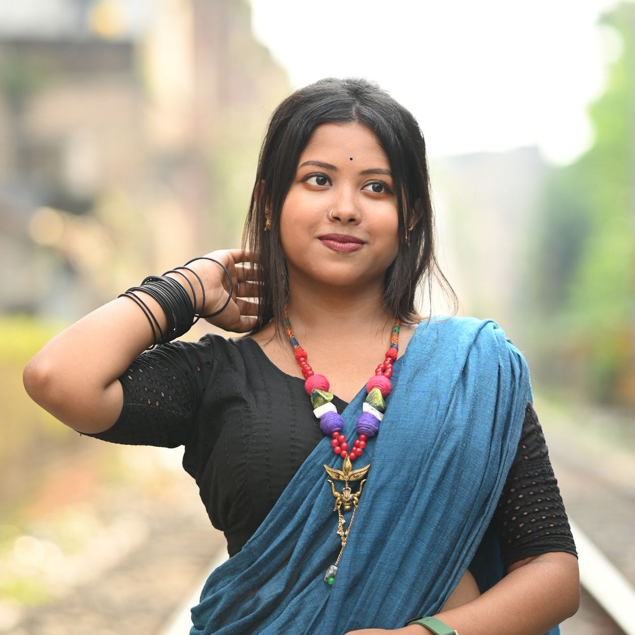 A South Asian woman in a sari standing on a railway track in Kolkata.